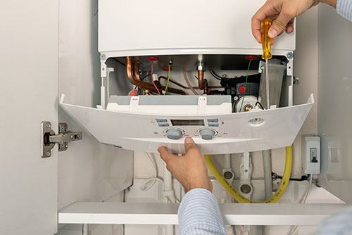 HVAC technician repairing an indoor boiler in Arvada