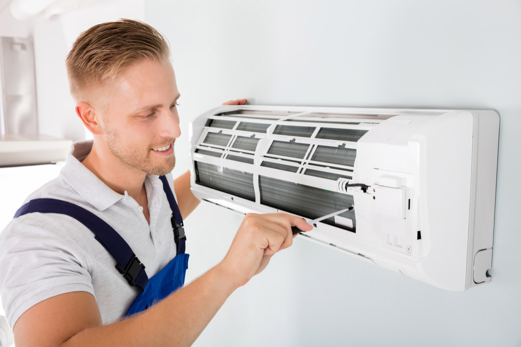 HVAC technician performing ductless air conditioning maintenance in Arvada