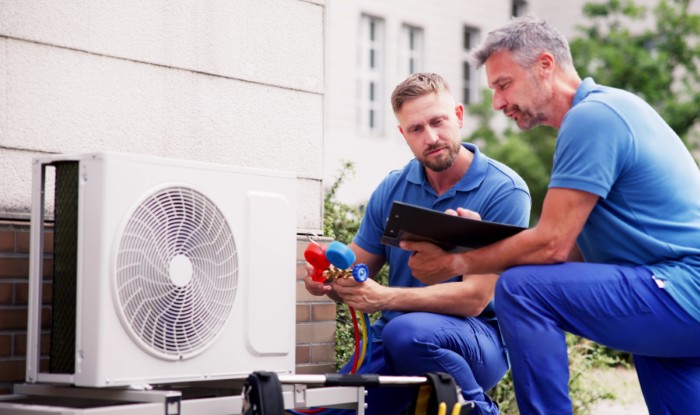 HVAC technicians installing an outdoor air conditioning unit in Arvada