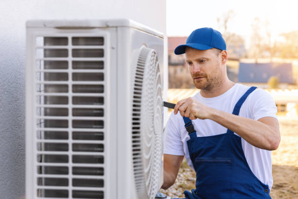 HVAC technician servicing an outdoor air conditioning unit in Arvada