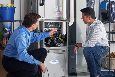 65df8c11f3e4c468cbd351a5_furnace repair vs replacement – Copy HVAC technician explaining furnace repair and maintenance to a homeowner in Arvada, CO