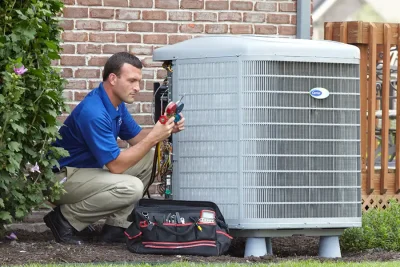 design-air-heating-and-air-conditioning-decatur-il-05 – Copy HVAC technician inspecting an outdoor air conditioning unit in Arvada, CO