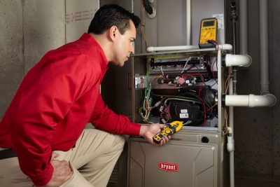 furnace repair Heating and air conditioning technician servicing an indoor furnace in Arvada, CO